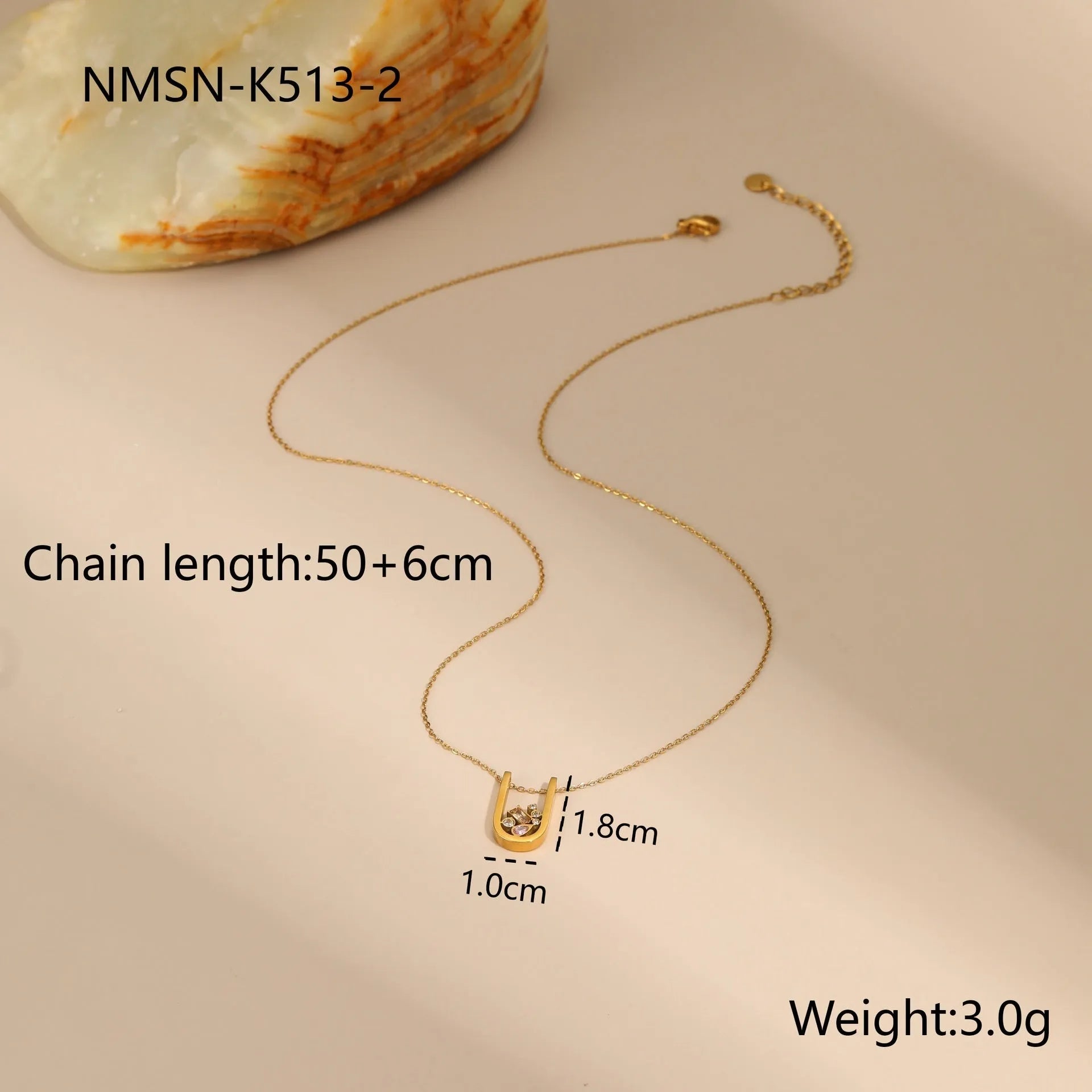 Geometric gold plated zircon jewellery set showing necklace, ring, and earrings on a grey background.