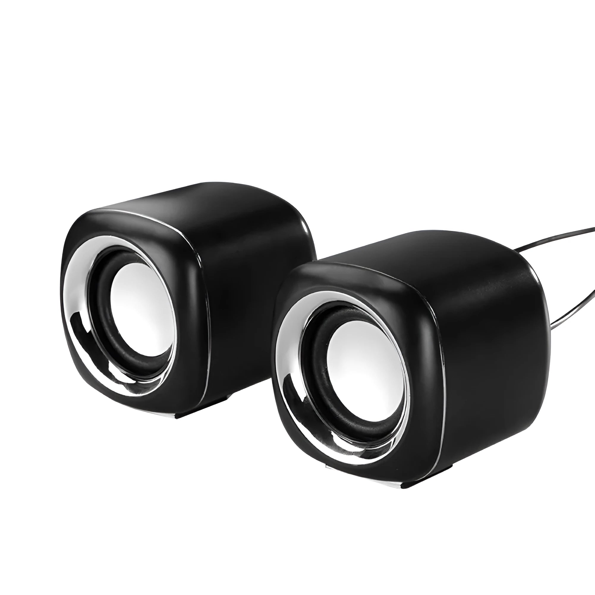 Pair of compact black wired desktop computer speakers with top volume scroll wheel next to a laptop.