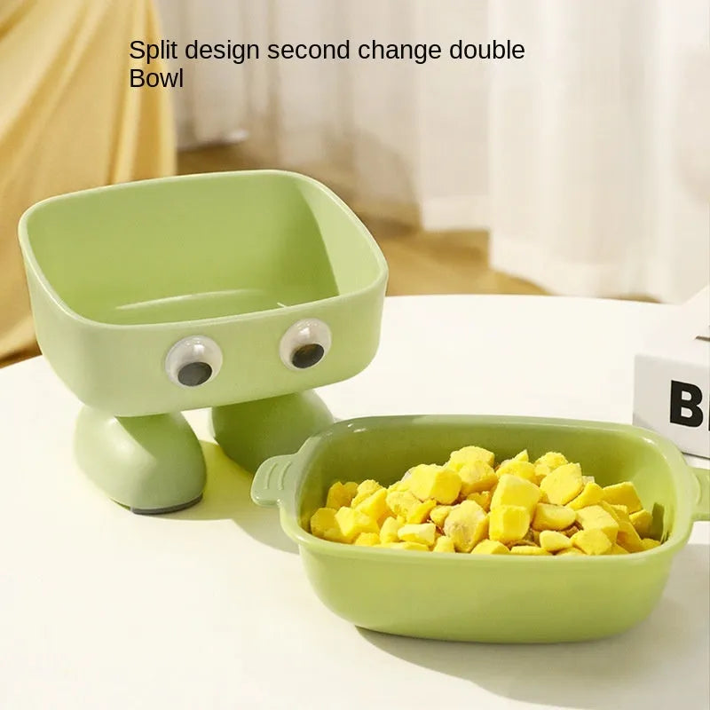 Green robot-shaped elevated cat bowl with tilted food dish and non-slip base.