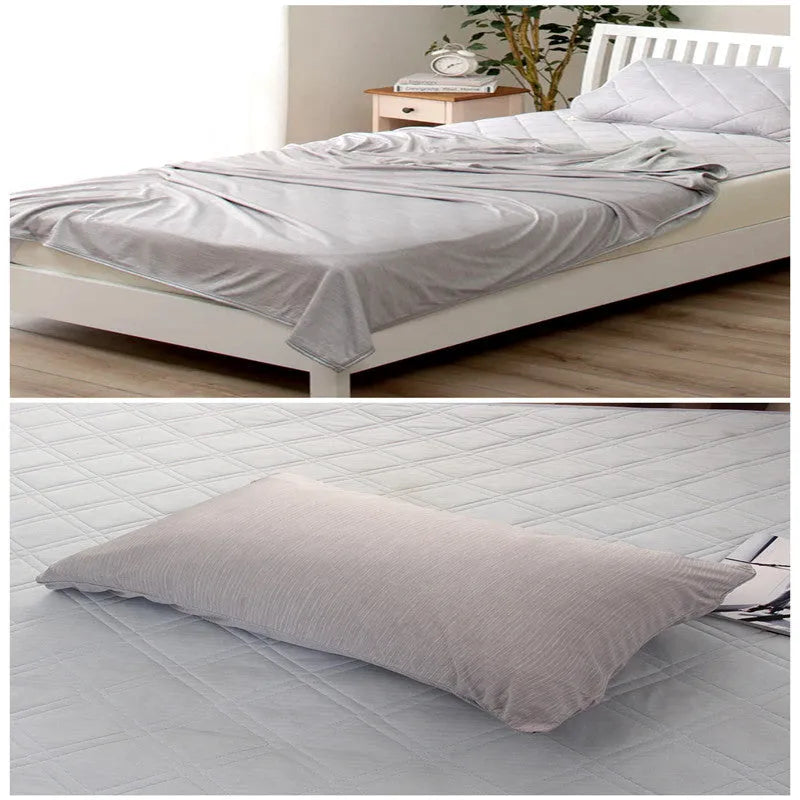 Blue and grey cooling blanket with Japanese Q-Max fibres on a bed.