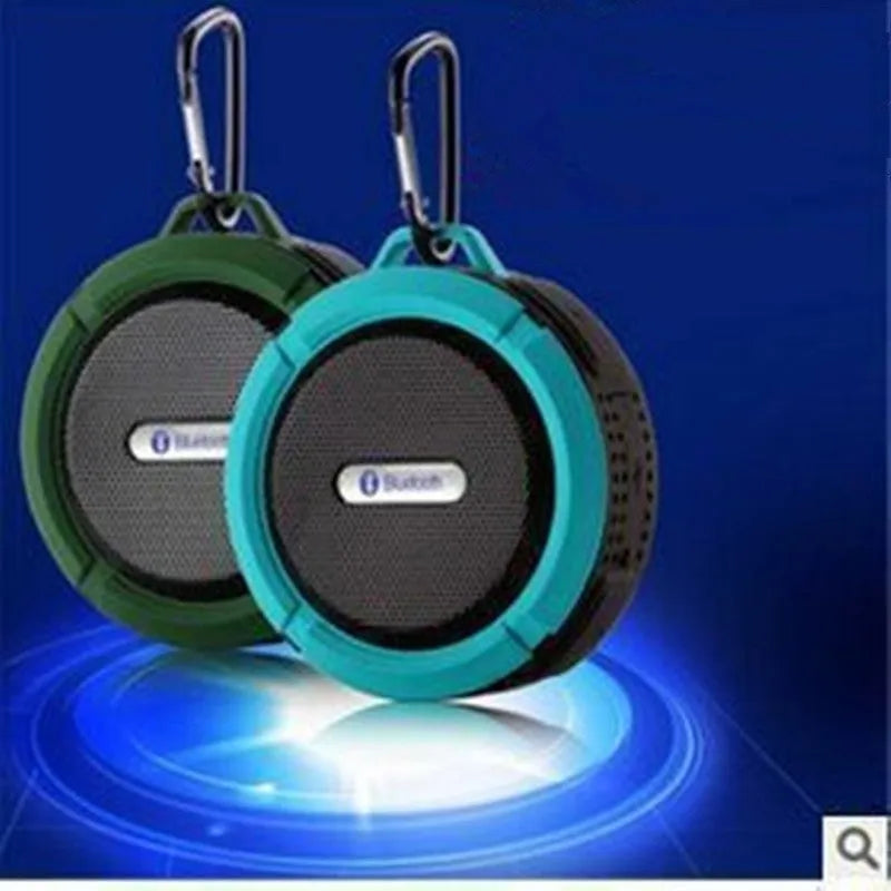 Portable waterproof Bluetooth speaker in multiple colours with a mountaineering buckle for bag attachment.