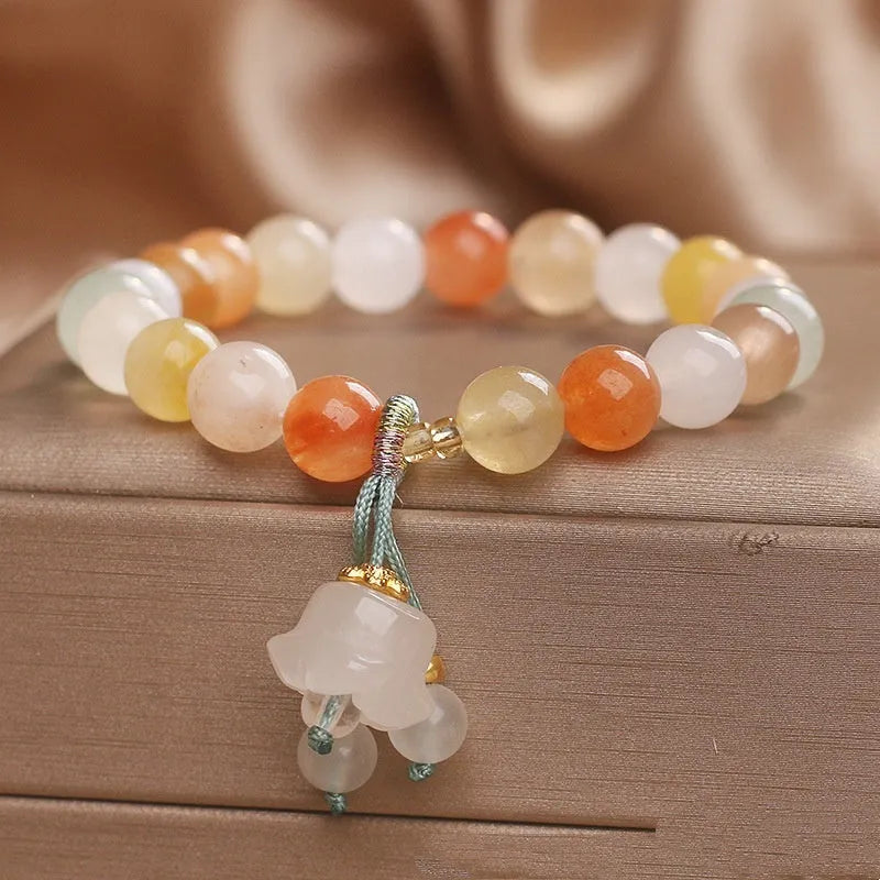 Natural Jinsi Jade round bead beaded bracelet with lily pendant on neutral background