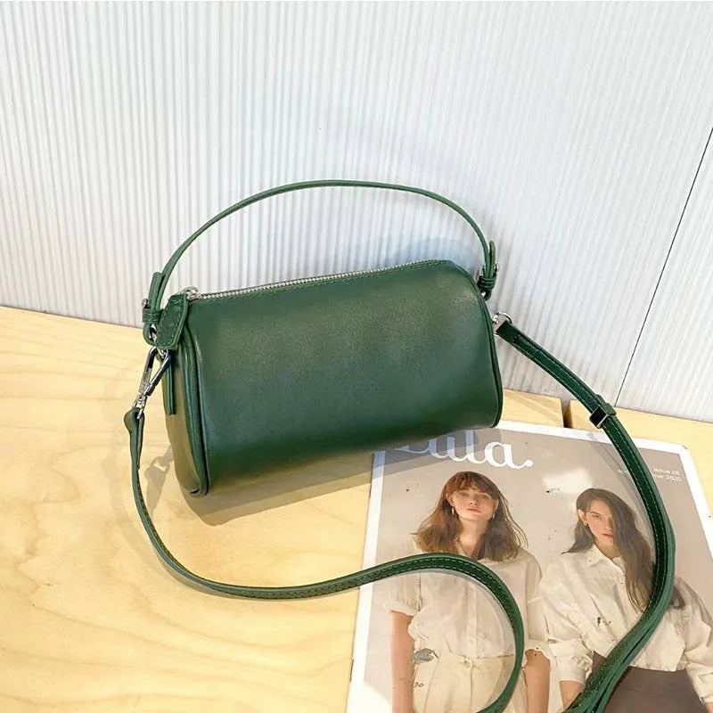 A soft genuine leather cylindrical crossbody bag for mobile phones in street style.
