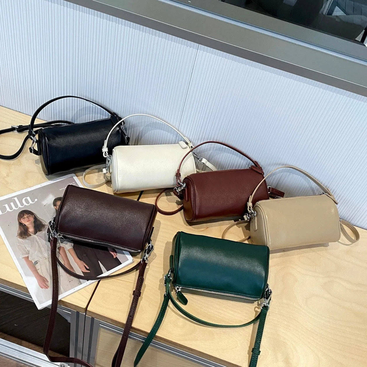 A soft genuine leather cylindrical crossbody bag for mobile phones in street style.