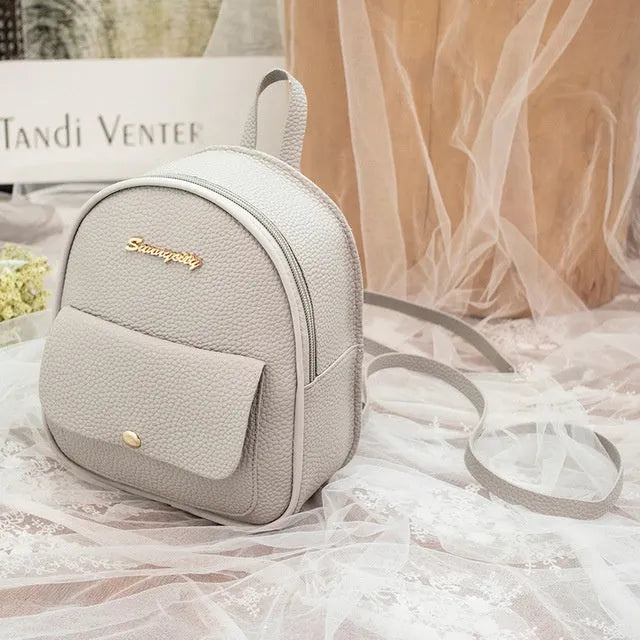 Women's small black PU leather backpack shoulder bag showing front zipper and dimensions