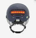 Cycling helmet with built-in red LED brake tail light on the back, shown in sizes M and L.