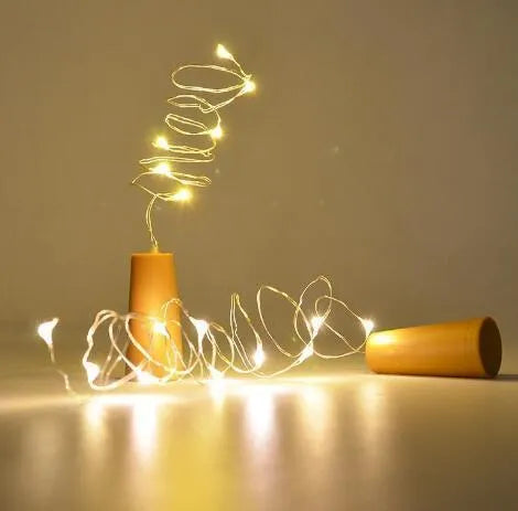Copper wire LED string light with 20 bulbs and a white plastic bottle stopper for decoration.
