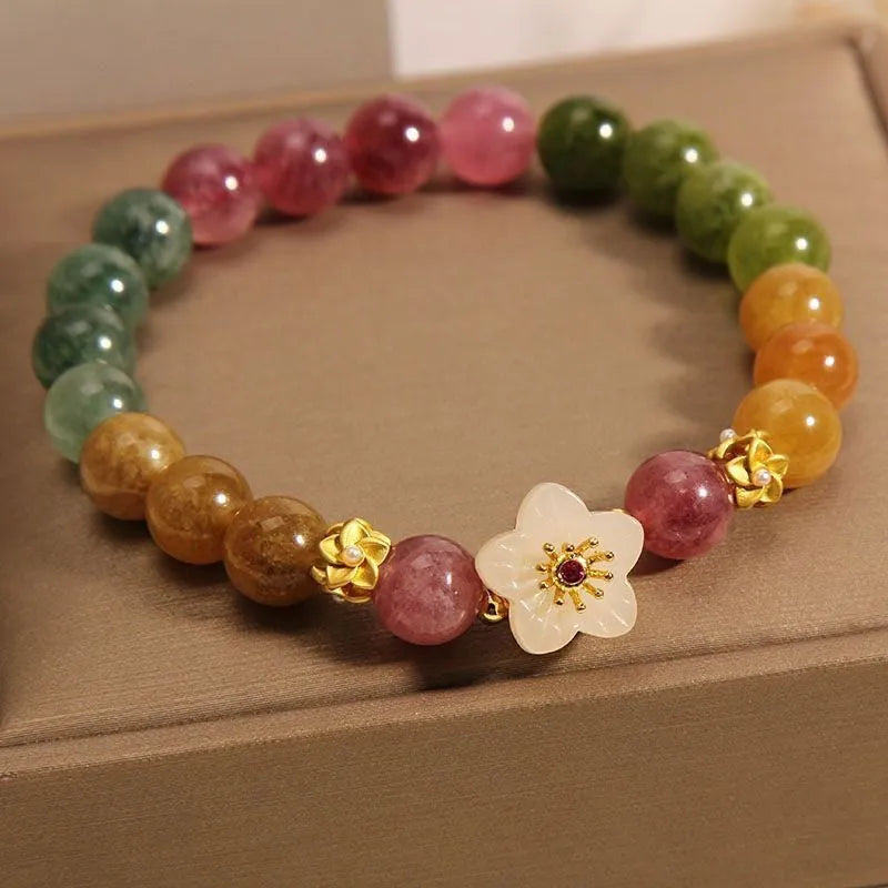 Natural colour tourmaline bracelet with floral beads and geometric design on wrist