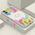 White and black silicone iPhone cases featuring a large rainbow smiley face design, shown with attached lanyards.
