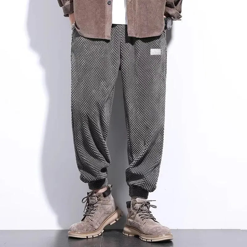 Men's grey straight-leg sweatpants with ankle ties on a plain background.