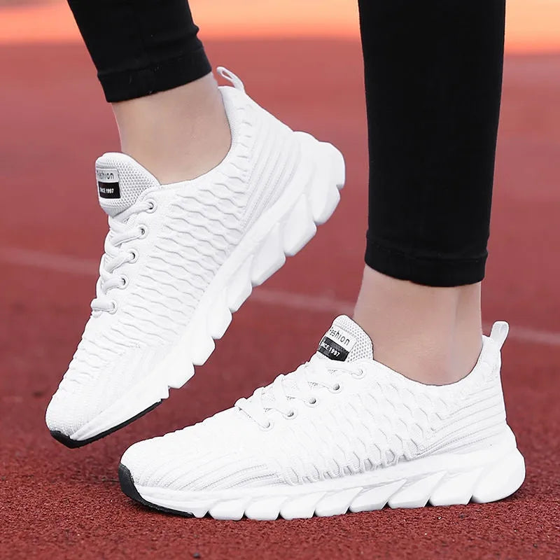 Women's running shoes with a fly weave upper in black, pink, and white colour options on a wear-resistant outsole.