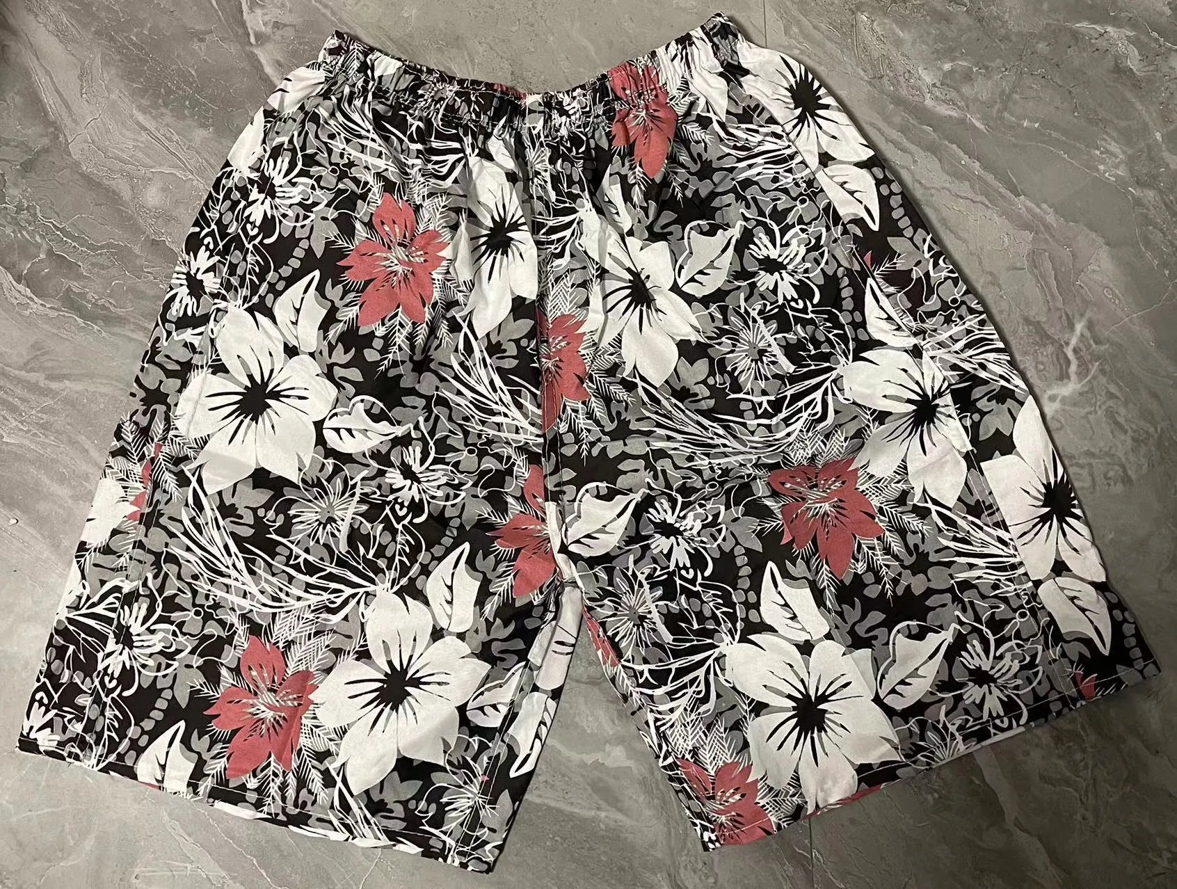Men's casual floral print five-point swimming trunks made from polyester fabric.