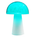 Small white mushroom-shaped decorative night light with RGB colours, remote control, on a wooden table.