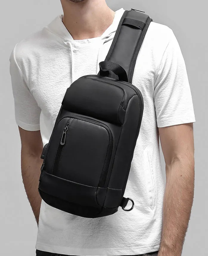 Black PVC outdoor shoulder bag showing computer pocket, air cushion strap, and organisational compartments