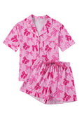 Pink bow print two-piece pajama set with a top and pants on a hanger