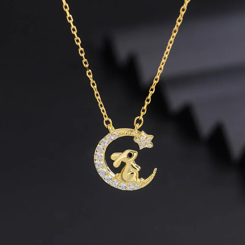 Gold colour copper rabbit and crescent moon full diamond necklace with micro inlay setting on studio background