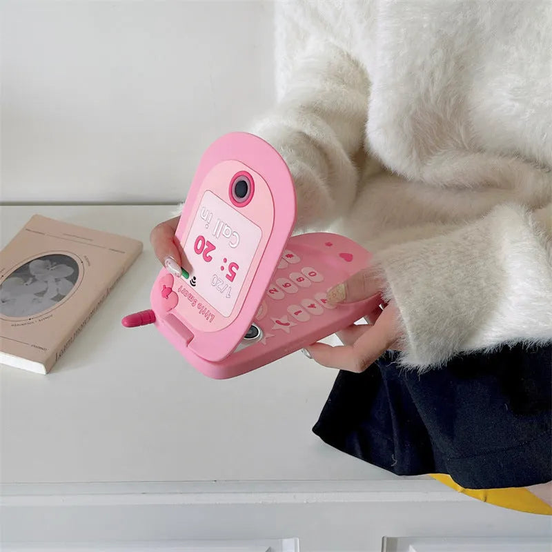 Pink silicone flip phone case open to show built-in mirror and iPhone compatibility.