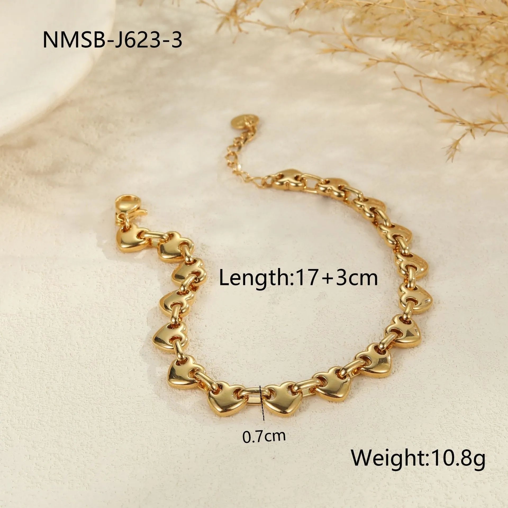 Hollowed-out heart geometry bracelet in stainless steel with gold electroplated finish on a wrist.