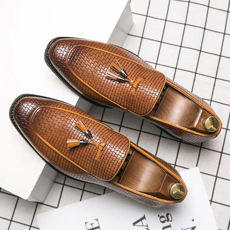 Men's black pointed slip-on business shoes with tassel detail on artificial PU upper.