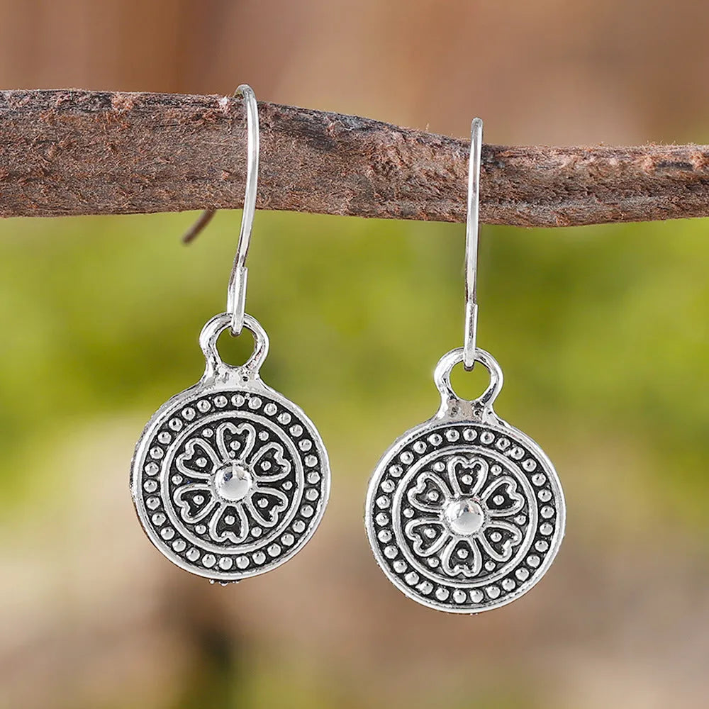 A pair of geometric zinc alloy earrings with a round distressed ethnic print in Bohemian retro style.