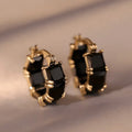 Geometric U-shaped gold earrings with black zircon crystal stones and round decorative elements