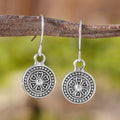 A pair of geometric zinc alloy earrings with a round distressed ethnic print in Bohemian retro style.