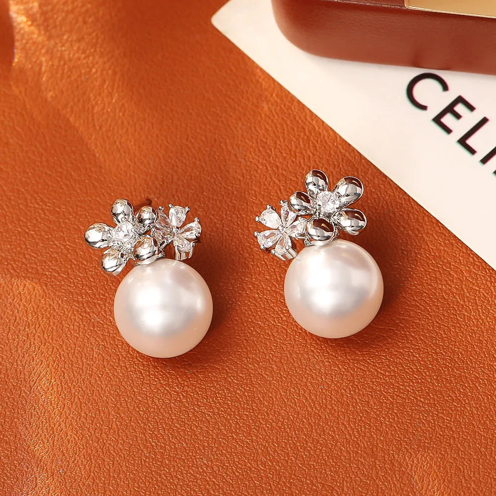 Pair of geometric round pearl and zircon stud earrings in gold plated finish on copper base