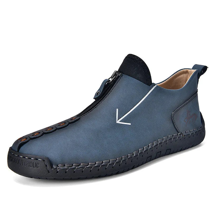 Men's black front-zip casual boots with round toe and low heel, showing the side zipper and rubber sole.