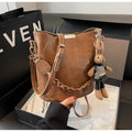 Women's retro bucket messenger bag in PU leather, 21x11x21 cm, with pendant detail and double shoulder strap connector