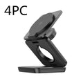 White foldable magnetic wireless charging phone stand on a wooden desk next to a mobile phone.