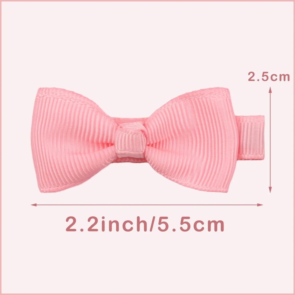 Assortment of pastel-coloured barrette and bow hair clips for babies on a white background.