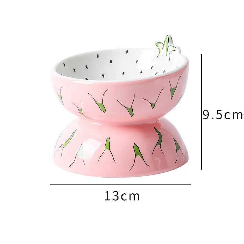Ceramic raised cat feeder bowl in orange patterned design on a white surface.