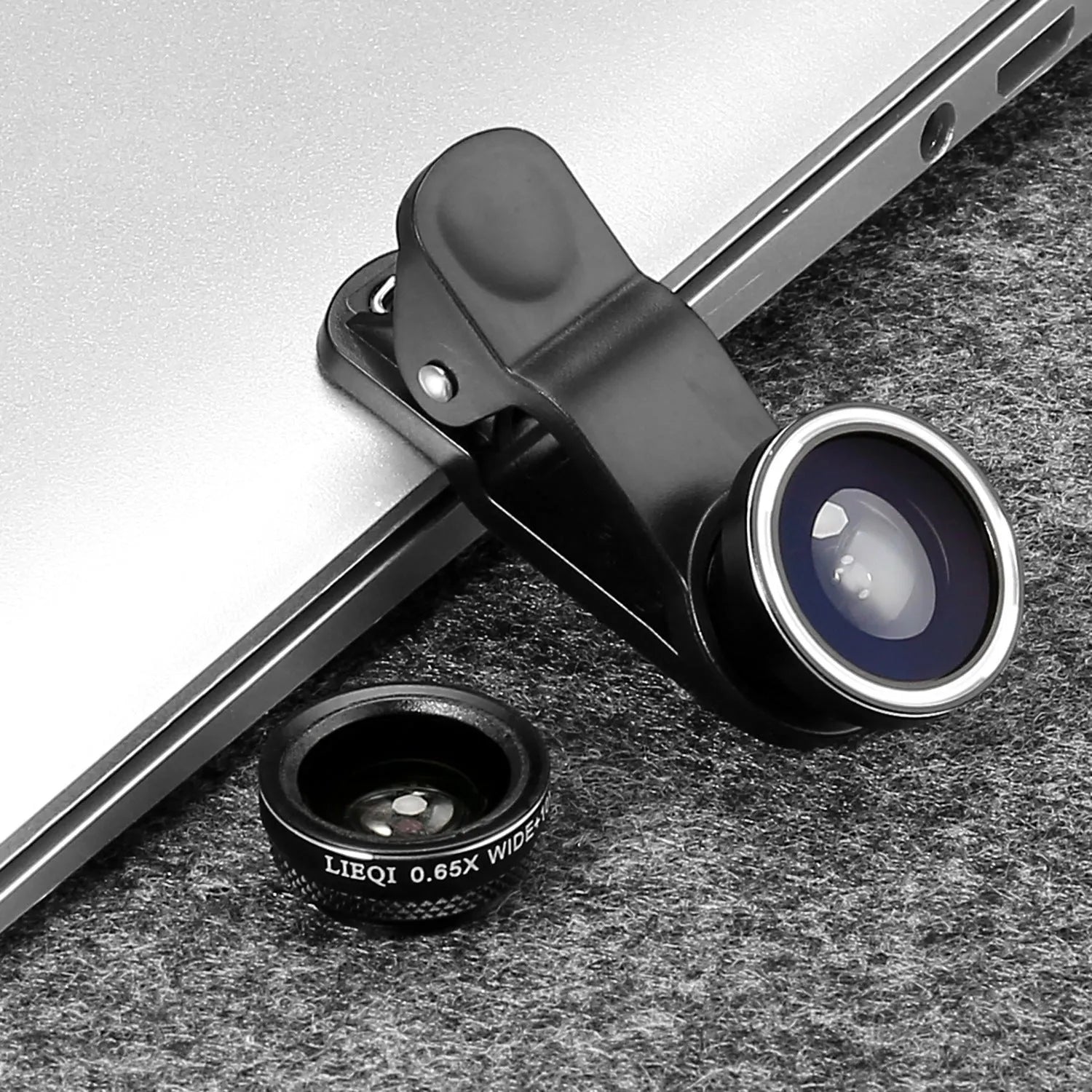 Mobile phone with a mini clip-on camera lens attached, alongside macro, fisheye, and wide-angle lenses in a case.