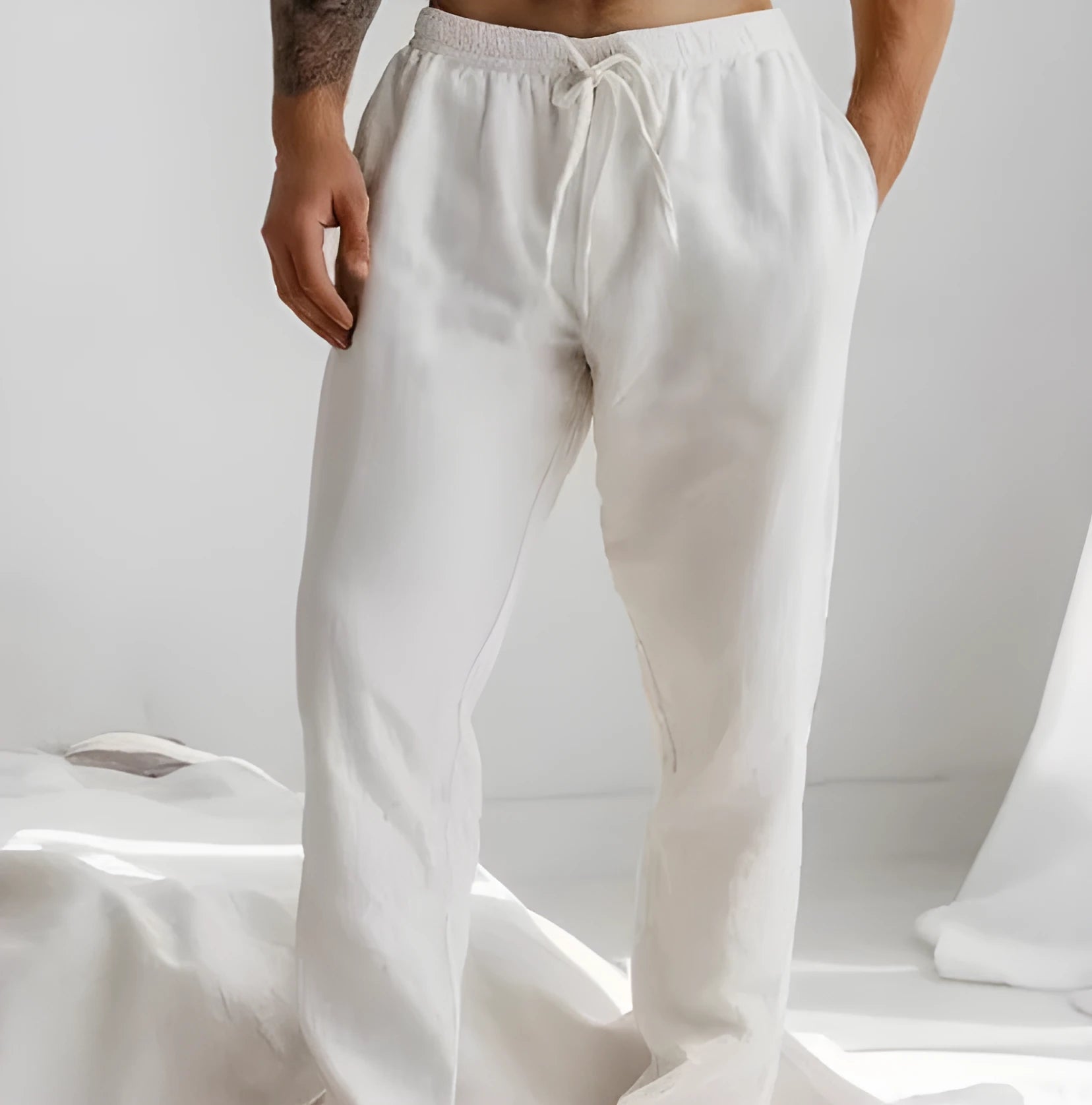 Men's loose straight-leg trousers in light blue with an elastic waistband and drawstring detail.