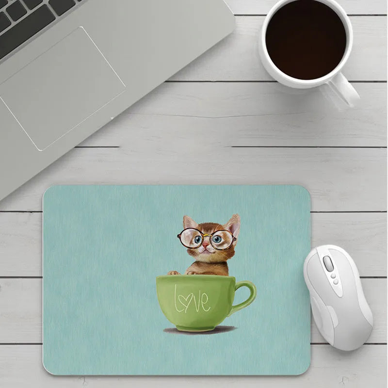 Custom cartoon design on a small black thickened mouse pad with stitching, shown on a desk.