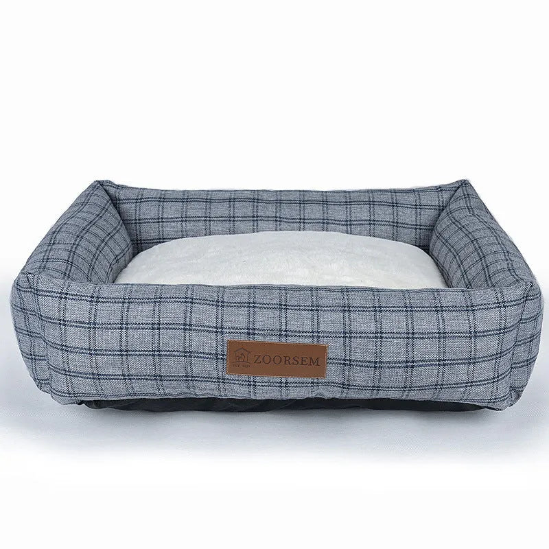 Grey plaid square cloth dog bed for medium-sized dogs on a wooden floor.