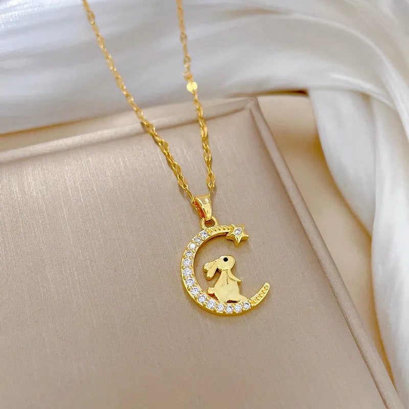 Gold colour copper rabbit and crescent moon full diamond necklace with micro inlay setting on studio background