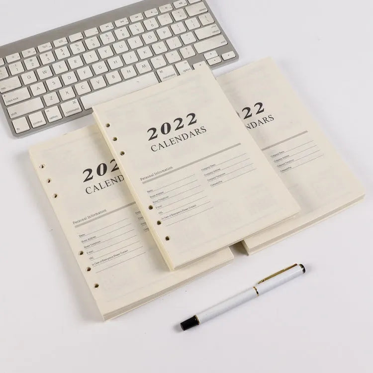 White A5 loose-leaf notebook inner pages with monthly plan layout on a plain background