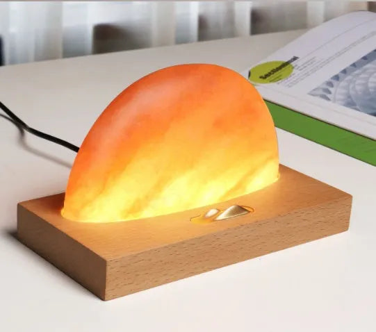 Natural crystal salt lamp with solid beech wood base and integrated Qi wireless phone charging pad.