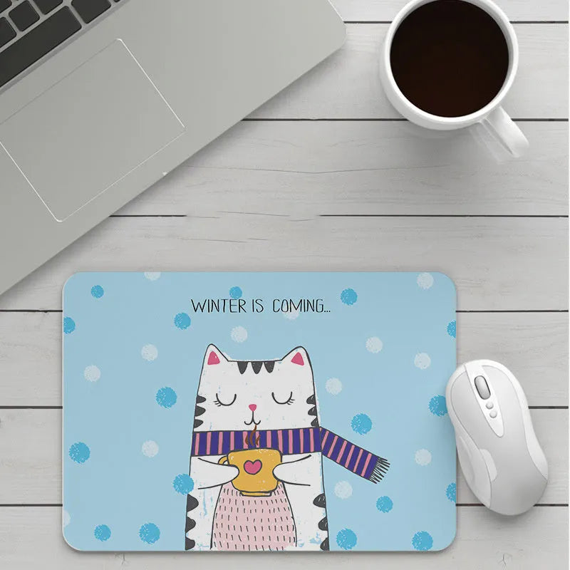 Custom cartoon design on a small black thickened mouse pad with stitching, shown on a desk.
