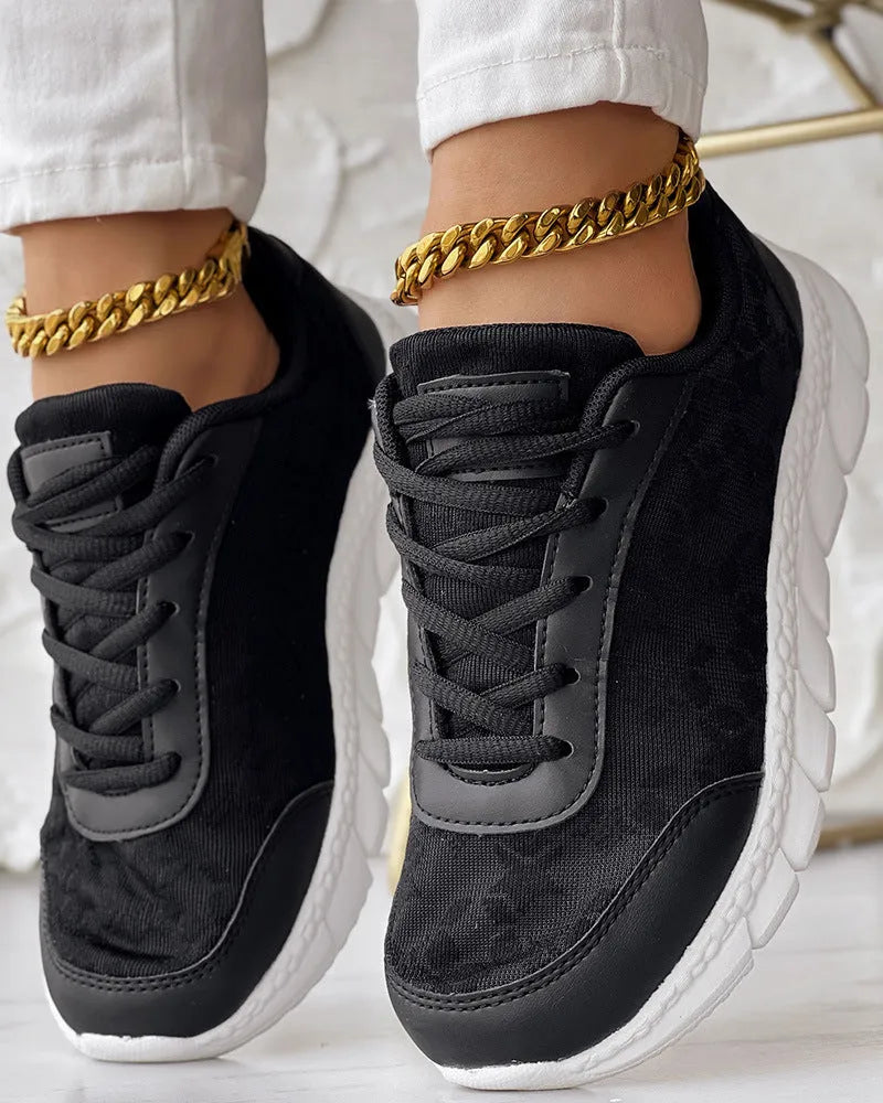 Women's white canvas running shoe with flat heel and soft sole on a light background.