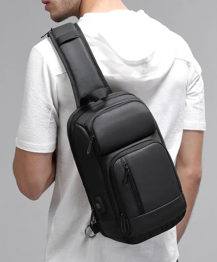 Black PVC outdoor shoulder bag showing computer pocket, air cushion strap, and organisational compartments