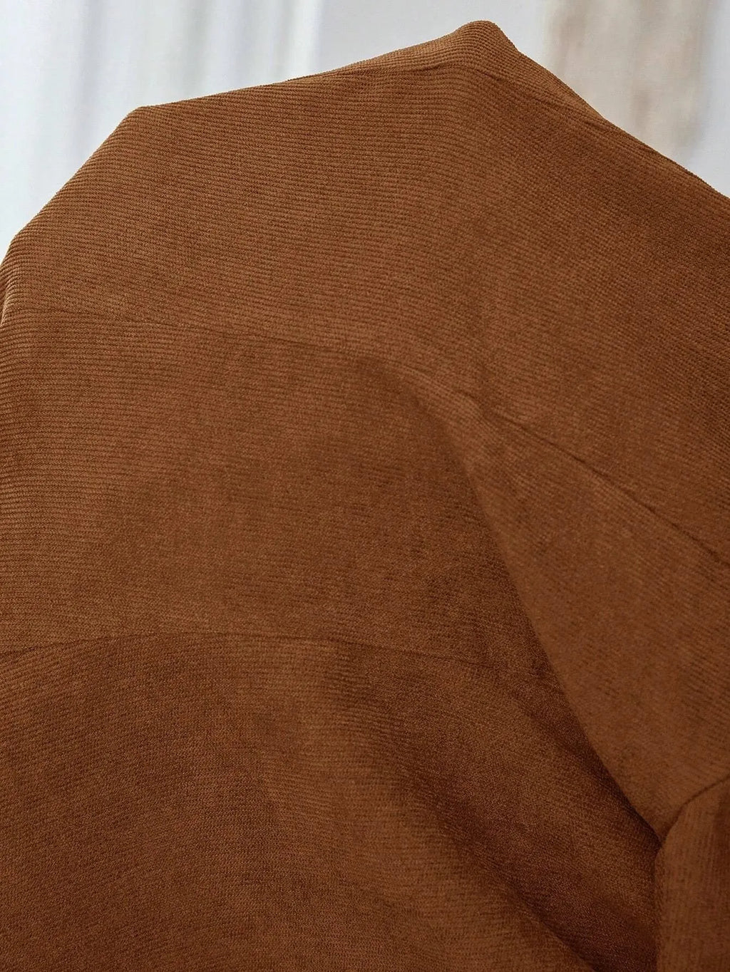 Brown men's single-breasted suit coat with lapels and long sleeves on a hanger