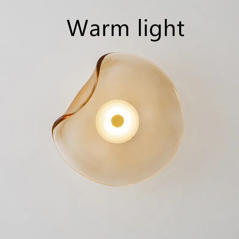 Round glass wall lamp in a choice of colours for bedroom bedside lighting.