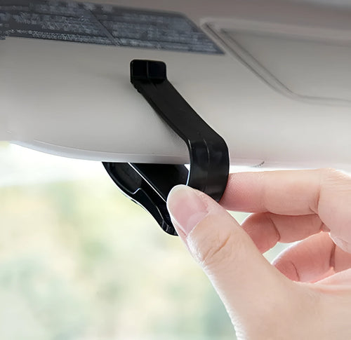 Black plastic car sunshade clip for holding glasses and cards on a vehicle visor.