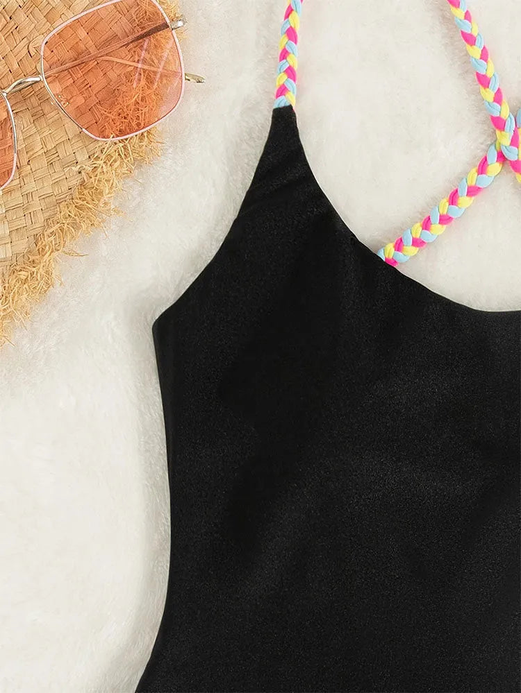 Black women's one-piece swimsuit with a backless and sleeveless design on a mannequin.