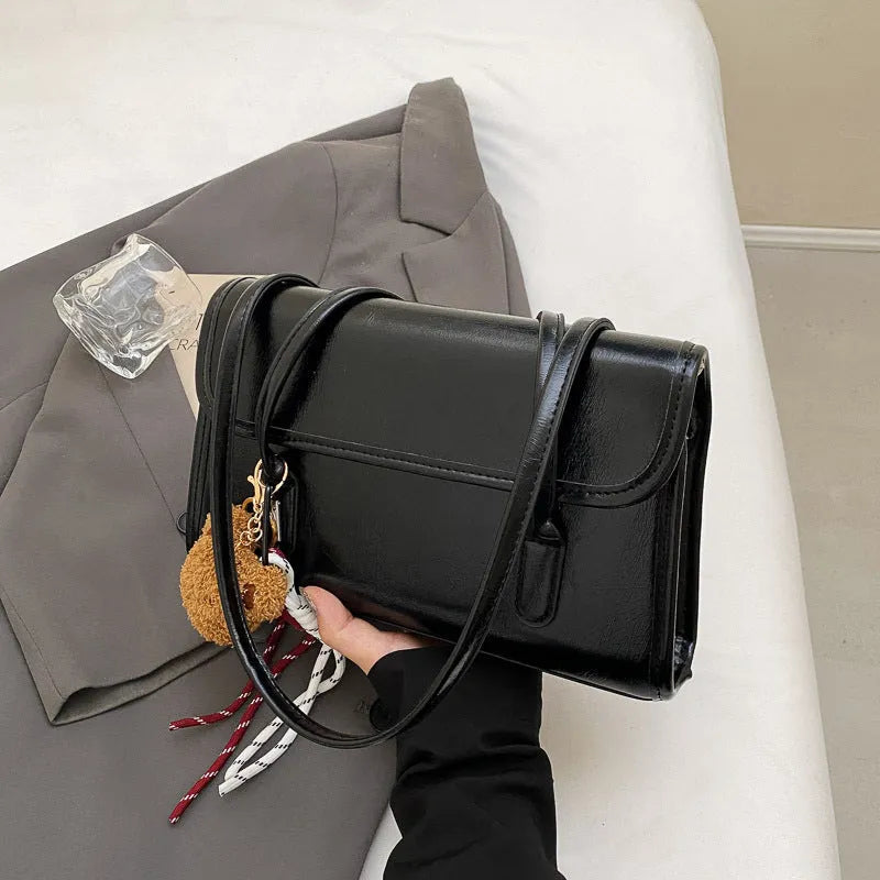Brown women's PU leather shoulder bag with a square shape, double straps, and a detachable pendant.