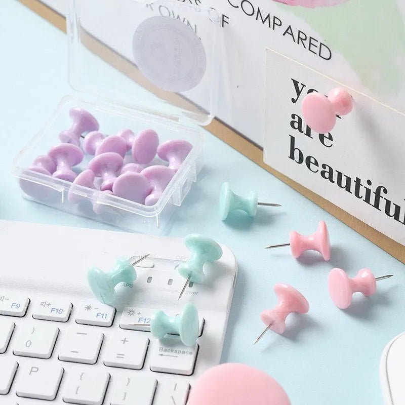 Plastic push pins in mint green, lavender, and pink, showing large and small sizes in a small box.
