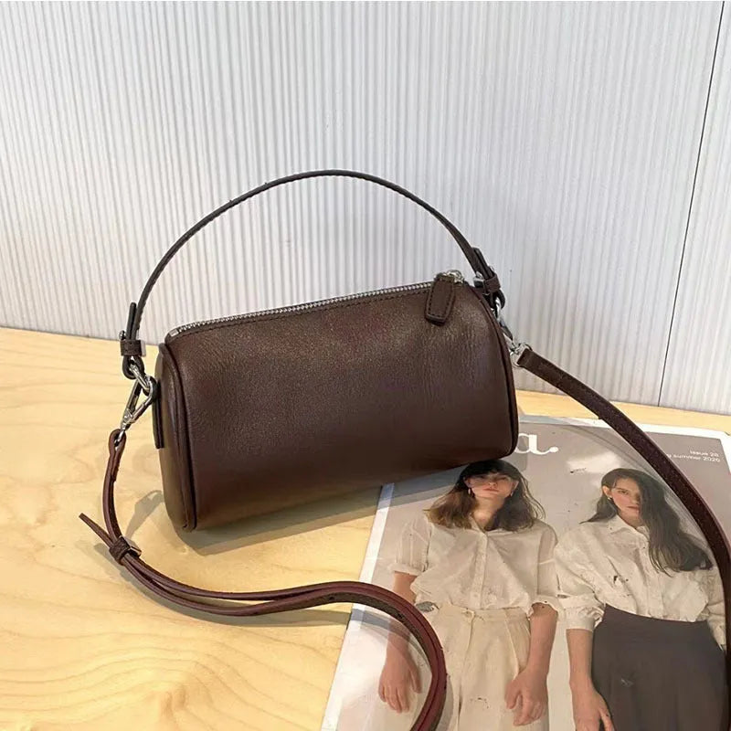 A soft genuine leather cylindrical crossbody bag for mobile phones in street style.