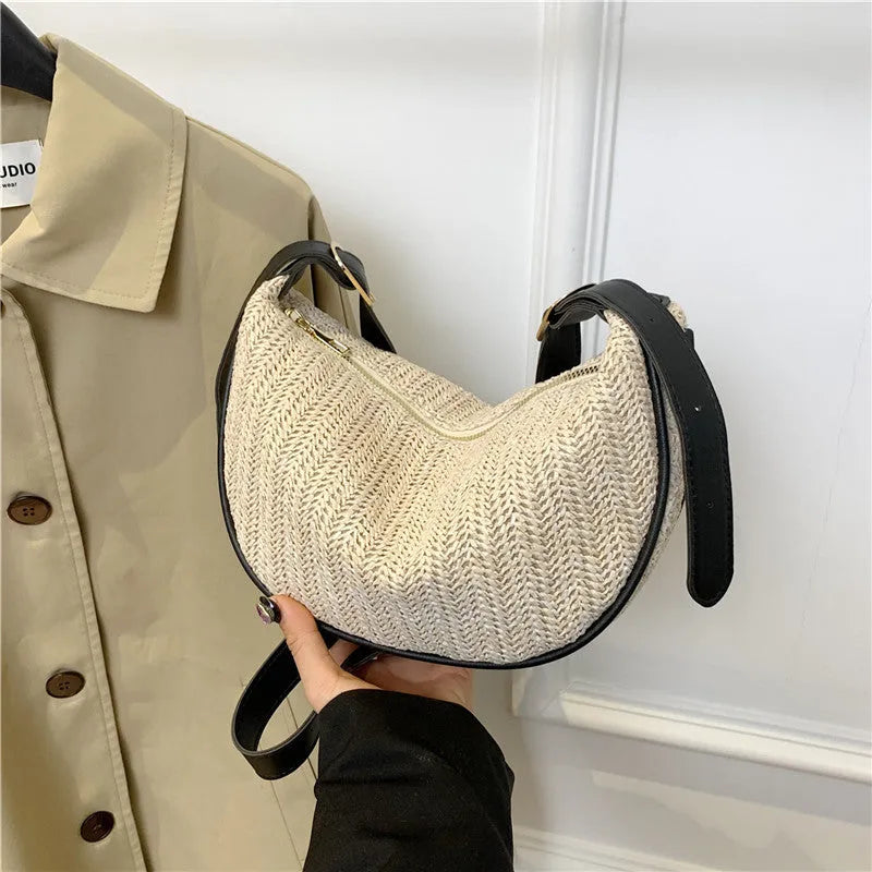 Women's straw woven crossbody bag showing woven texture and internal phone and document compartments